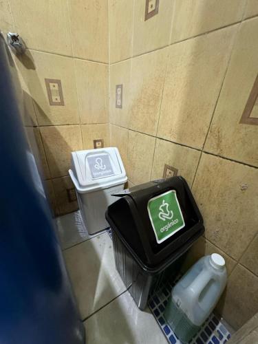 a bathroom with two trash cans in a stall at Casa fide cómoda in Panajachel