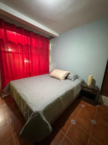 a bedroom with a bed with a red curtain at Casa fide cómoda in Panajachel