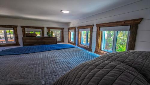 a bedroom with a large bed and windows at The Sundance Tiny Home in Pauma Valley