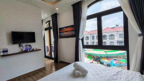 a bedroom with a large window with a view of a building at The Star hotel DTH3-31 in Phú Quốc