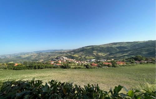 a small town in a green field with mountains in the background at Az Ag Ricciarelli N in San Giuliano di Puglia
