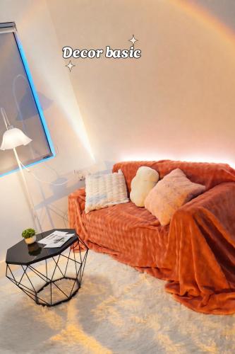 a living room with a couch and a table at The Tiny Cineroom & Homestay in Buon Ma Thuot