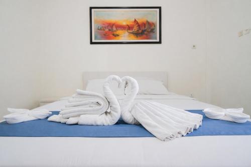 a bed with two swans made out of towels at Tripletree Sinergi Hotel Tretes in Pasuruan