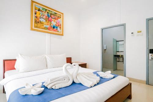 two swans towels on a bed in a room at Tripletree Sinergi Hotel Tretes in Pasuruan