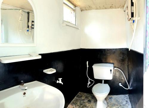 a bathroom with a white toilet and a sink at Kithul Cottage 2 in Watagoda