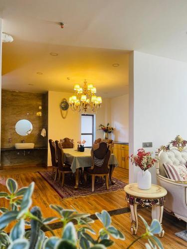 a dining room with a table and chairs and a chandelier at Pines Dirang Homestay in Chug