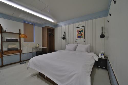 a bedroom with a large white bed in it at 그랑메종 바오밥 호텔 in Gwangju