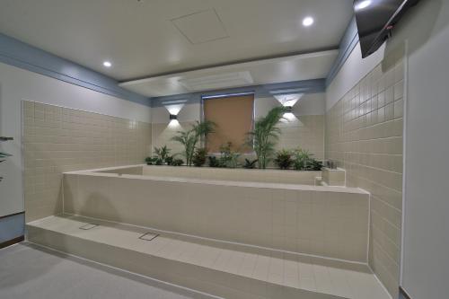 a bathroom with a tub with plants in a mirror at 그랑메종 바오밥 호텔 in Gwangju