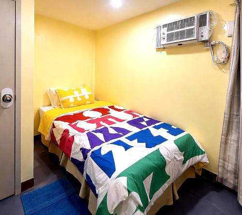 a bedroom with a bed and an air conditioner at Belechl Ranch Studio Rental - Cozy Compact Room with Private Bathroom in Koror