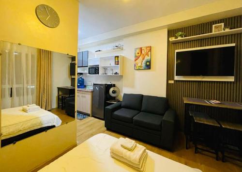 a living room with a couch and a bedroom at Chic and Affordable Studio in Davao City