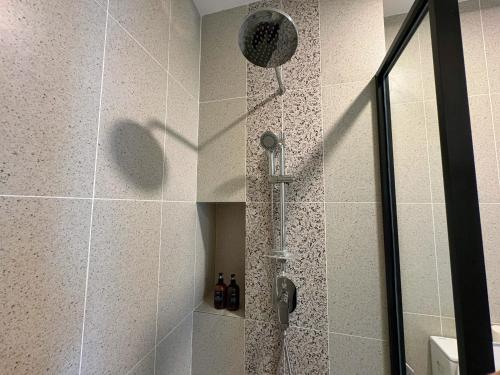 a shower with a shower head in a bathroom at Le Arch Suite - Georgetown Komtar View Studio in George Town