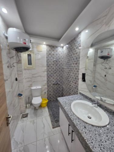 a white bathroom with a sink and a toilet at Jemmy Home in Sharm El Sheikh