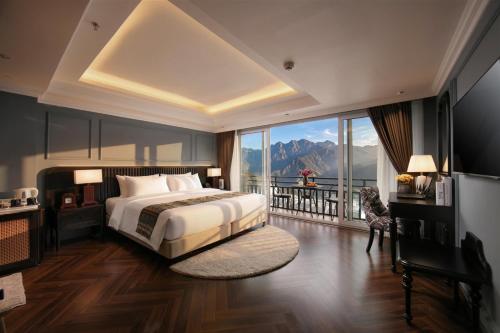 a bedroom with a bed and a large window at Sapa Horizon Hotel & Skybar in Sapa