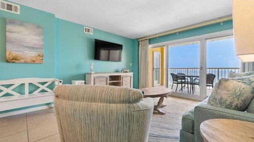 a living room with a couch and a chair and a balcony at Beachfront Bliss in Gulf Shores