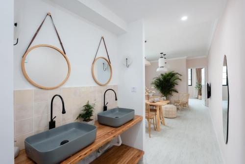 a bathroom with a blue sink and mirrors on the wall at Pine & Cedar Suites – Hua Xiao Ye in Shanghai
