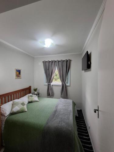 a bedroom with a green bed and a window at Espaço Van Gogh Poços de Caldas in Poços de Caldas