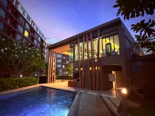 a house with a swimming pool in front of a building at Calm Home in Phuket