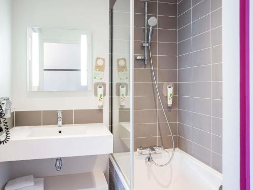a bathroom with a sink and a shower at ibis Styles Lorient Caudan in Caudan