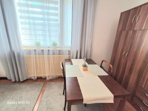a table and chairs in a room with a window at ,,Arts Home,, ,ZAPRASZAM ,blisko las,dużo przyrody, blisko centrum kardiologii,centrum szkoleniowe,trasa na Lublin,Ukrainę,mieszkanie przestronne,czyste,spokojna okolica,blisko Aldi,Lidl,Żabka,Rossmann,pkp, ztm in Warsaw