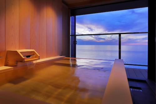an empty room with a view of the ocean at 游水亭いさごや in Tsuruoka