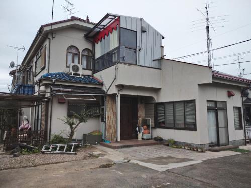 a white house with a lot of windows at Kounotori no Sato no Yado - Vacation STAY 13076 in Kōnosu