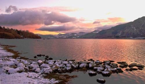 a large body of water with snow on the rocks at Ravenstone Lodge Country House Hotel in Keswick