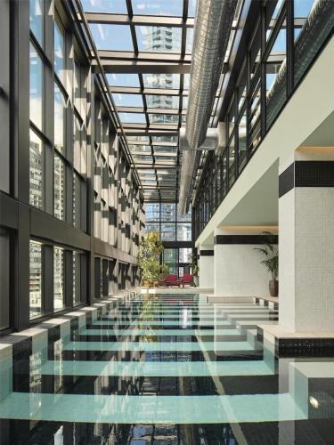 a large pool in a building with glass ceilings at Hannah St Hotel Melbourne in Melbourne