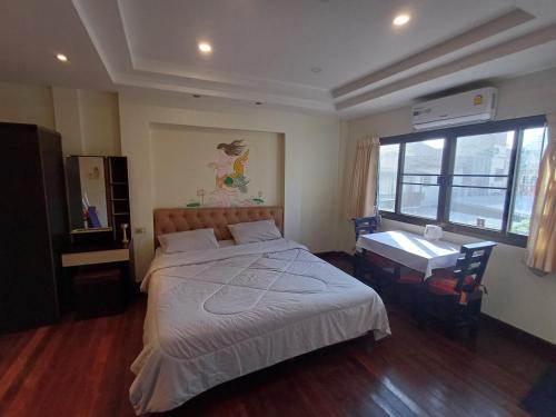 a bedroom with a bed and a desk and a window at Skippers inn pier 55 Bar&Guesthouse in Hua Hin