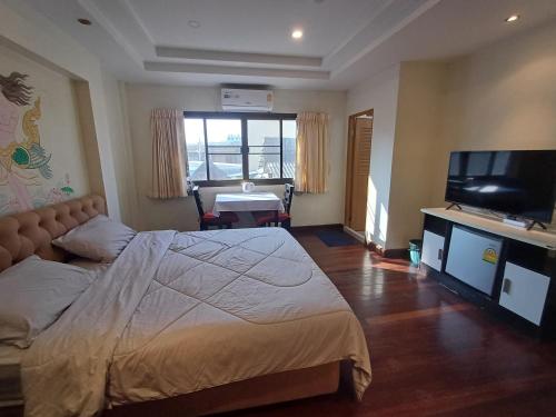 a bedroom with a bed and a flat screen tv at Skippers inn pier 55 Bar&Guesthouse in Hua Hin
