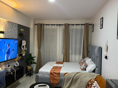 a bedroom with a bed and a flat screen tv at Membley star heights -Naivera in Ruiru