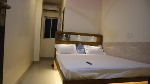 a bedroom with a bed with white sheets and pillows at Tokyo Inn in Howrah