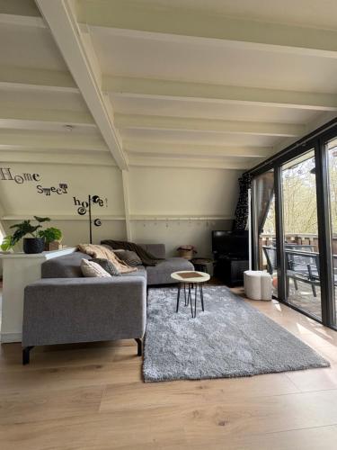 a living room with a couch and a table at Chalet Séquoia 138 Nature, piscine et chien bienvenu à Durbuy in Durbuy
