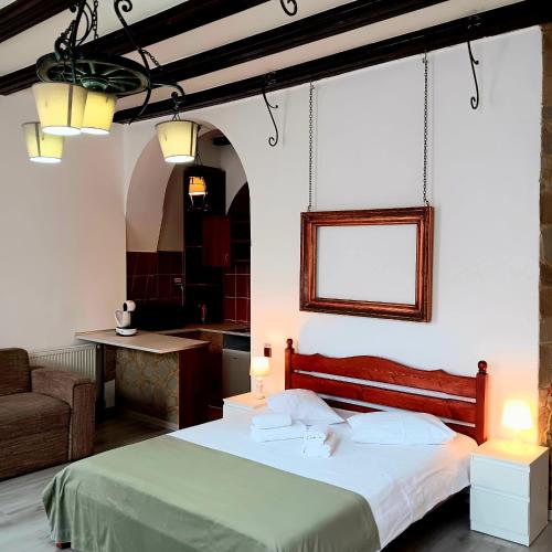 a bedroom with a bed and a chair and a table at Noemi Old Town in Braşov