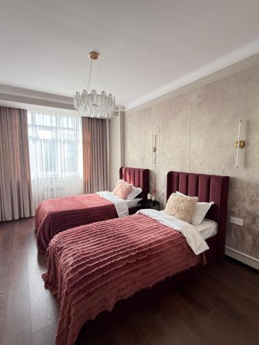a hotel room with two beds and a chandelier at Ala-Too Central Square Residence in Bishkek