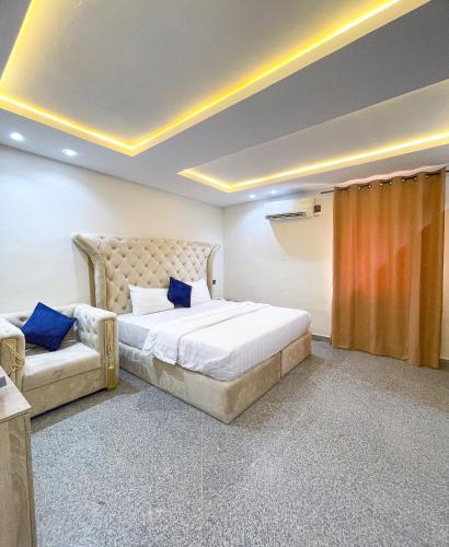 a bedroom with a large bed and a couch at Oasis hotel and suites in Lagos