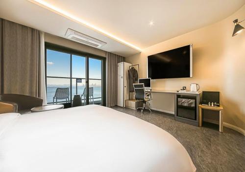 a hotel room with a bed and a television at Brown Dot Yeongildae Beach in Pohang in Pohang