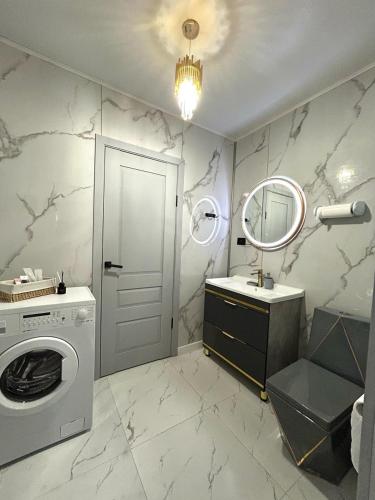 a bathroom with a washing machine and a mirror at Villa De Ray in Almaty