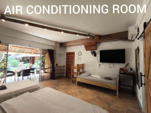 a room with two beds and a flat screen tv at Sulu Sunset Beach Resort in Nauhang