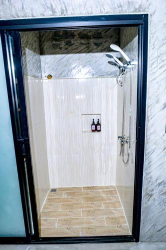 a shower with a glass door in a bathroom at คีรีเขาสกริเวอร์ Keereekhaosokriver in Khao Sok National Park