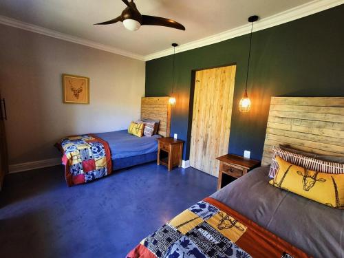 a bedroom with two beds and a ceiling fan at SoetHoek Farm Retreat in Alexandria