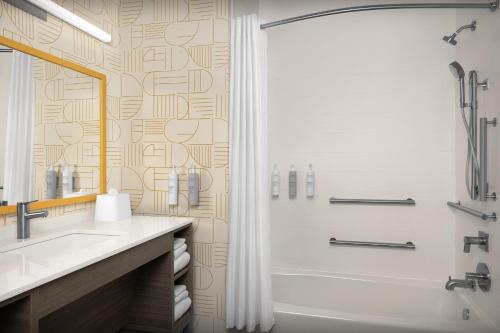 a bathroom with a shower and a sink and a tub at Home2 Suites By Hilton Taylor in Taylor