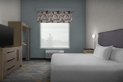 a hotel room with a bed and a window at Home2 Suites By Hilton Taylor in Taylor
