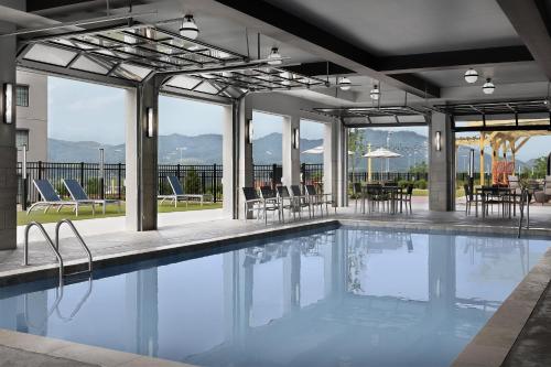 a swimming pool with tables and chairs in a building at Tempo By Hilton Pigeon Forge in Pigeon Forge
