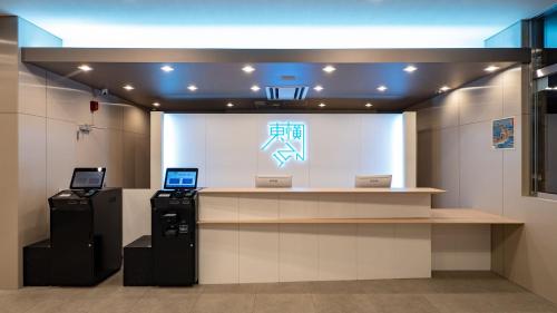 a store with a counter with two computers on it at Toyoko Inn Kochi in Kochi