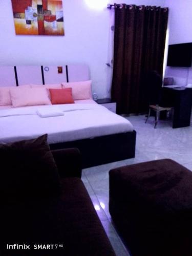 a bedroom with a bed and a couch in a room at Pine smart apartment Apo in Abuja