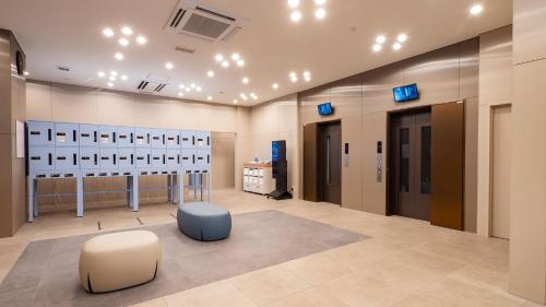 a dressing room with two ottomans and two stools at Toyoko Inn Kochi in Kochi