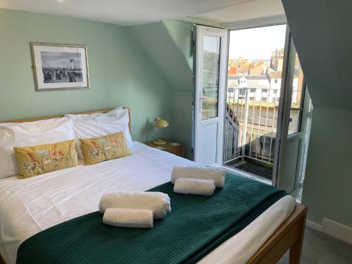a bedroom with a bed with two towels on it at Monarch in Weymouth