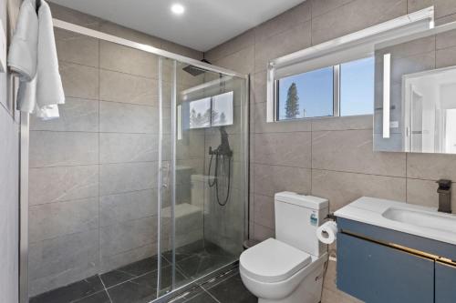 a bathroom with a shower and a toilet and a sink at The Beachside Gathering in Anna Bay