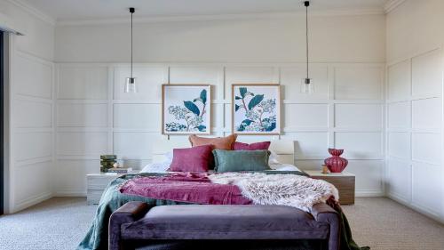 a bedroom with a bed with pink and green pillows at Grants - West Cambewarra, Longreach in West Cambewarra