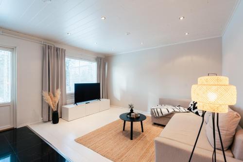 a living room with a couch and a television at Arctic Circle Holiday Homes in Rovaniemi